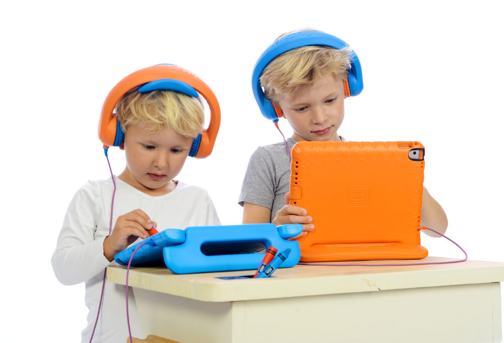 Zwei Kinder, die den Ton von iPads mit den Kopfhörern von KidsCover hören.